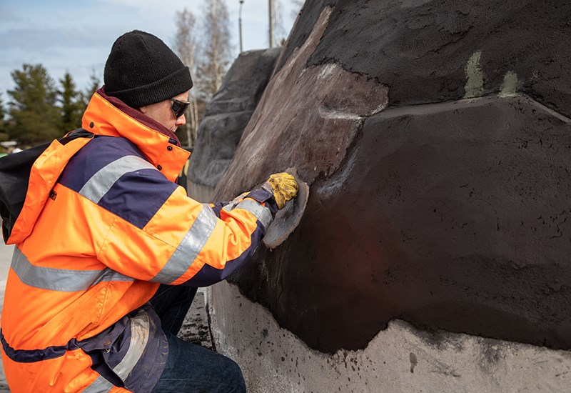 Raimo Saarinen työstää kalliota jäljittelevän pinnan tekstuureja silikonimuotilla